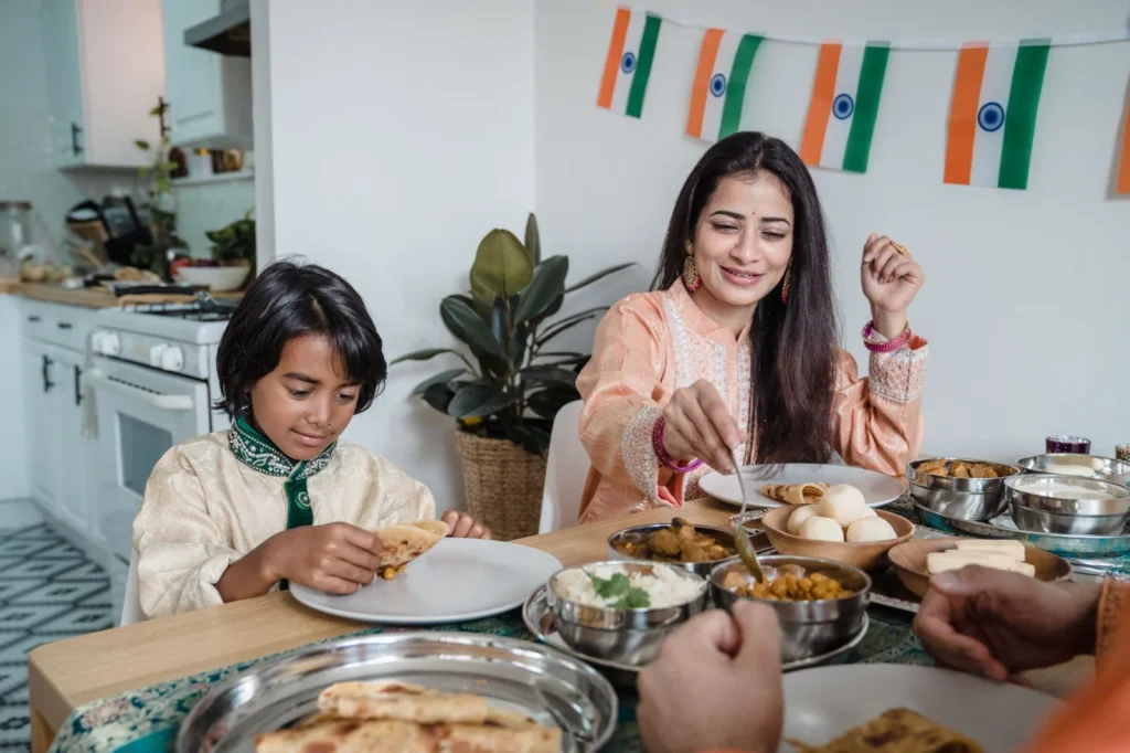 Mother and son enjoying a traditional Indian meal together at home, embracing cultural heritage.